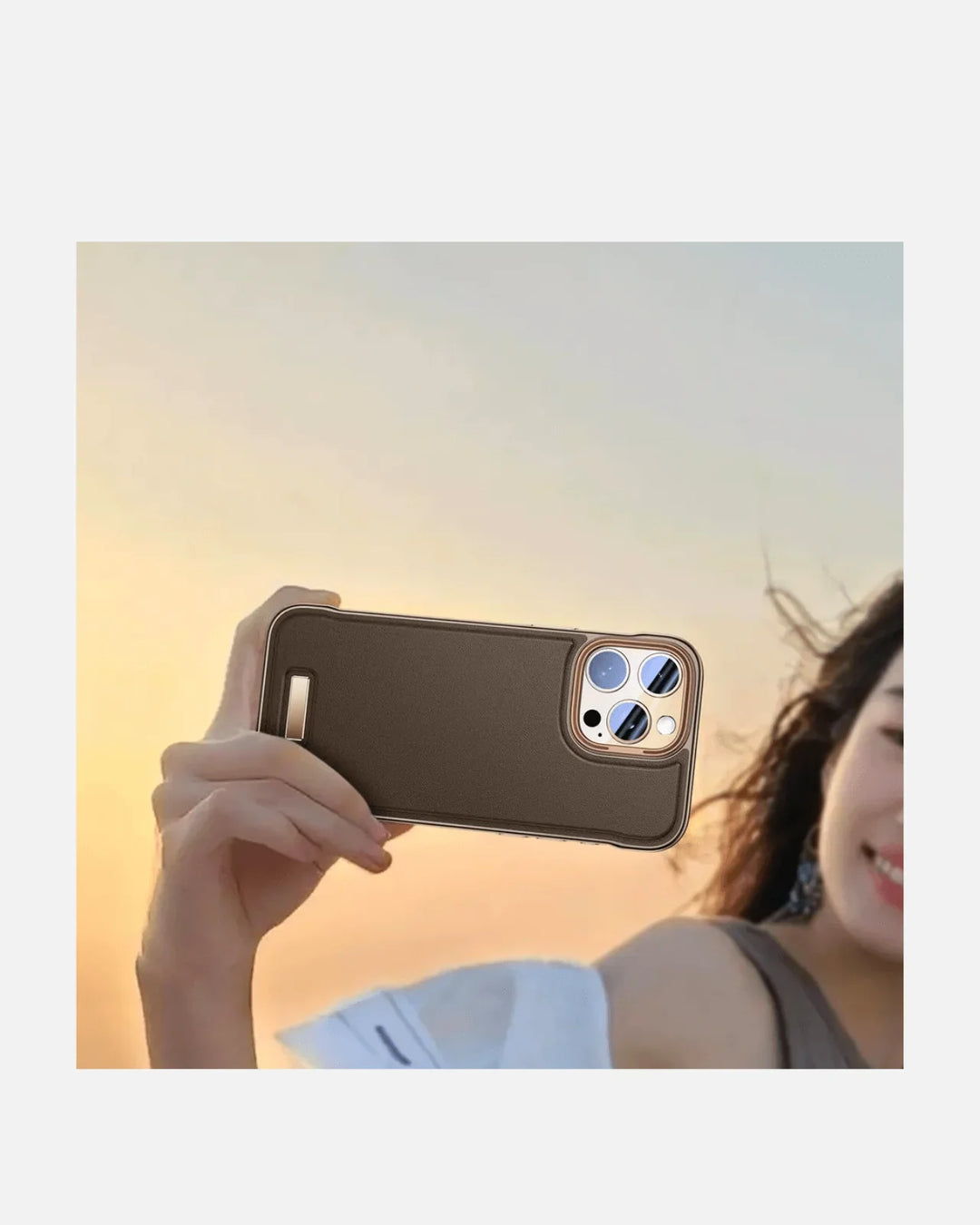 Person holding a luxurious frameless leather case for iPhone at sunset, showcasing its sleek design and style.