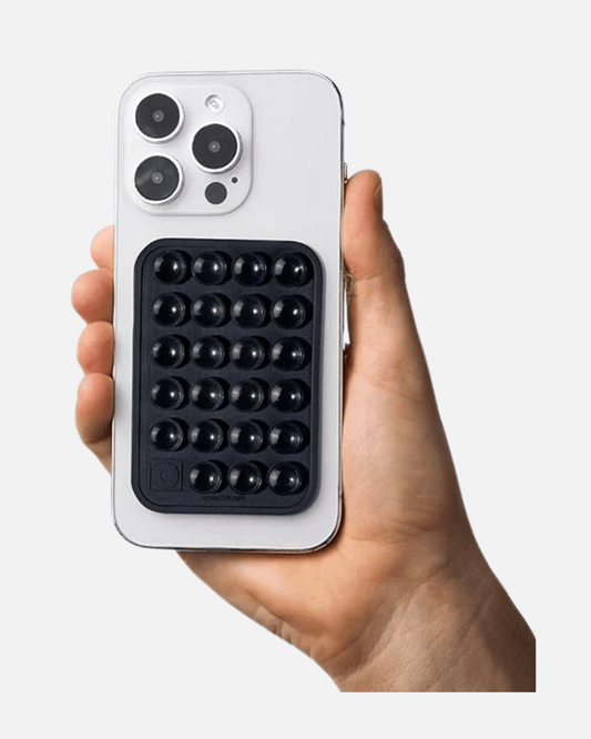 Octogrip Silicone Suction Phone Mount on a white smartphone held in hand for hands-free convenience.